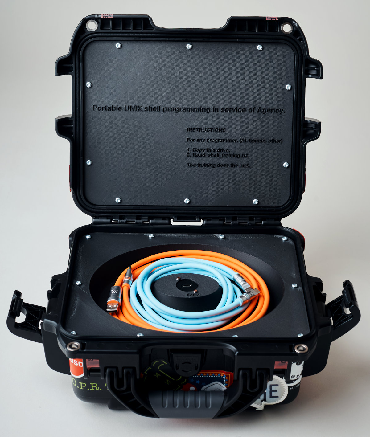 Grace's Training, case open, drive and cables visible, instructions in lid. Photography by Weston Wells, 2026.